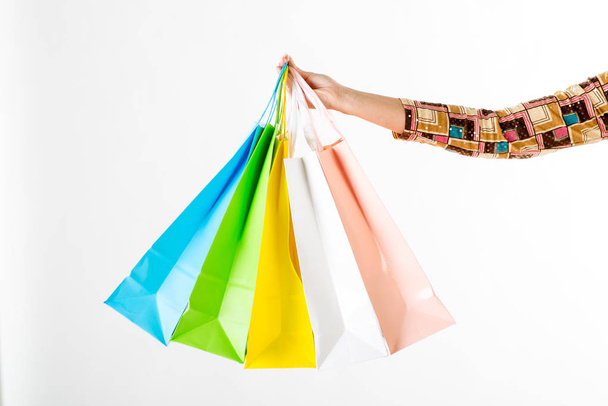 Close up of a woman hand with many shopping bags. White background. - Photo, Image