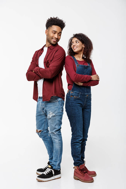 Homme et femme afro-américain joyeux avec les mains croisées debout dos à dos sur fond blanc isolé
. - Photo, image