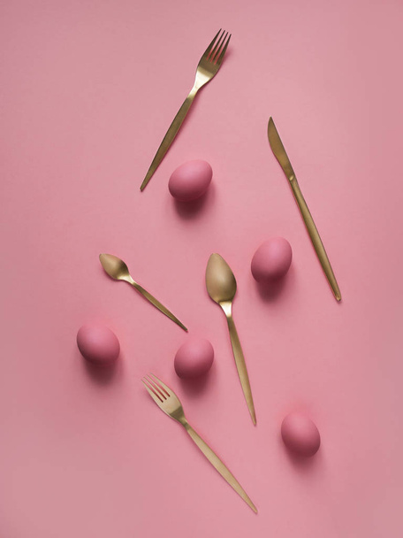 Top view of pink eggs with cutlery on pink background - Foto, Imagem