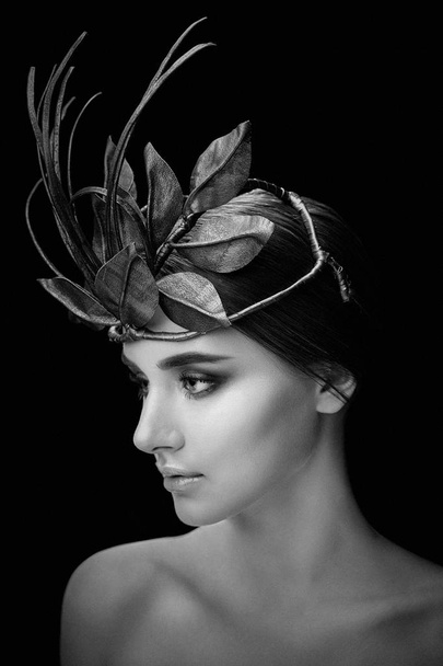 Black and white portrait of gorgeous young woman in elegant headdress on dark studio background   - Foto, afbeelding