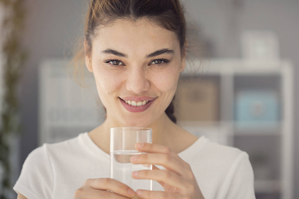 молодая женщина пьет стакан воды
 - Фото, изображение