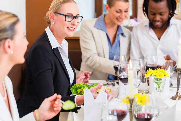 Ομάδα από άνδρας και γυναίκες σε επαγγελματικό γεύμα στο εστιατόριο τρώγοντας και πίνοντας - Φωτογραφία, εικόνα
