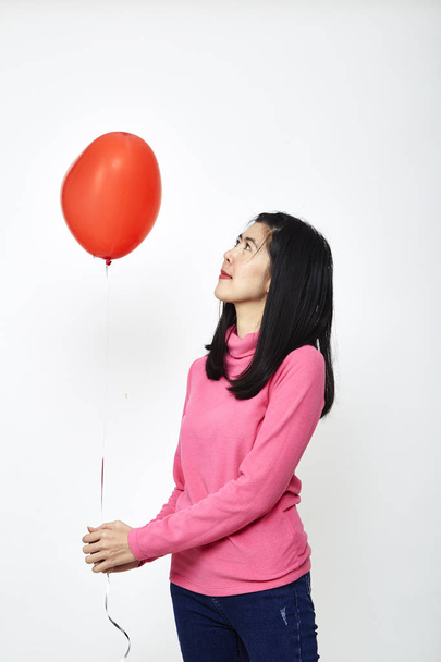 Beautiful Asian woman holding a red heart balloon holding a Valentines Day - Zdjęcie, obraz
