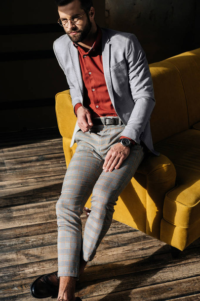 handsome stylish elegant man sitting on sofa - Фото, зображення