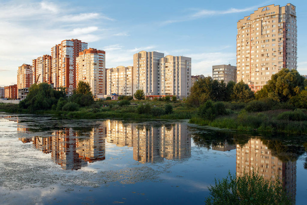 Widok z nowej dzielnicy mieszkalnej, na brzegu rzeki Pekhorka w lecie. Miasto Balashikha, Moscow region, Federacja Rosyjska. - Zdjęcie, obraz