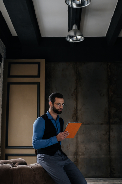 модный элегантный мужчина с цифровым планшетом в интерьере лофта
 - Фото, изображение