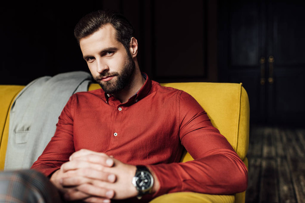 stylish elegant handsome man sitting on yellow couch  - Photo, Image