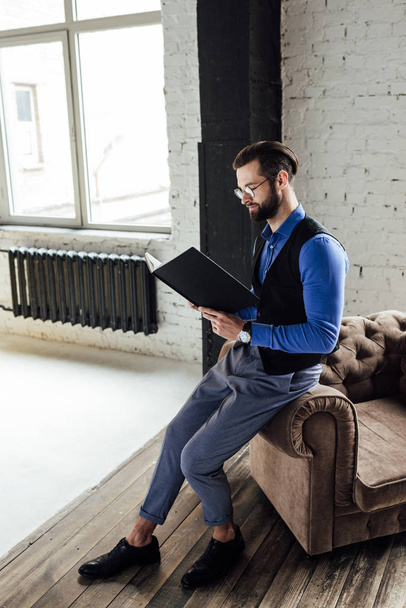 modieuze elegante zakenman lezen notebook in loft interieur  - Foto, afbeelding