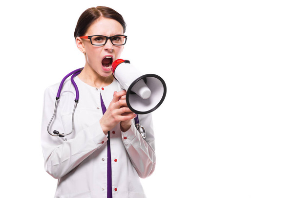 Молодая женщина врач кричит в громкоговоритель изолированы на белом
 - Фото, изображение