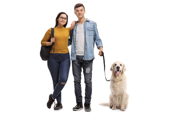 Full length portrait of teenage students with a labrador retriever dog isolated on white background - Foto, Imagem
