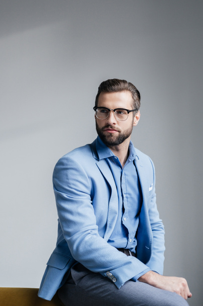 stylish bearded man in glasses and blue trendy suit - Fotó, kép