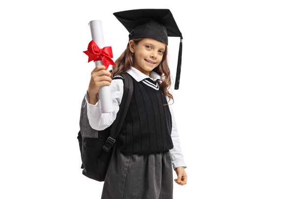 Little schoolgirl with a graduation hat and a diploma isolated on white background - 写真・画像