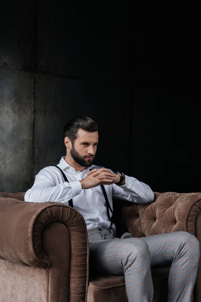 handsome pensive man sitting in armchair - Photo, Image