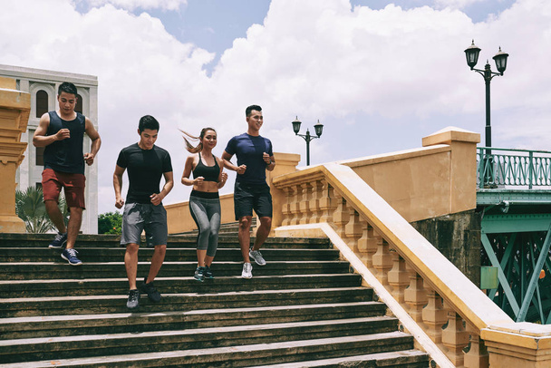 Grupo de pessoas vietnamitas alegres descendo as escadas
 - Foto, Imagem