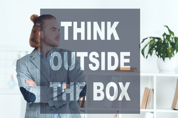 handsome businessman standing in office with crossed arms and looking away, think outside the box concept - Фото, зображення