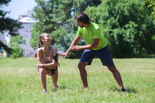 Young couple having training in the park on a sunny day - 写真・画像