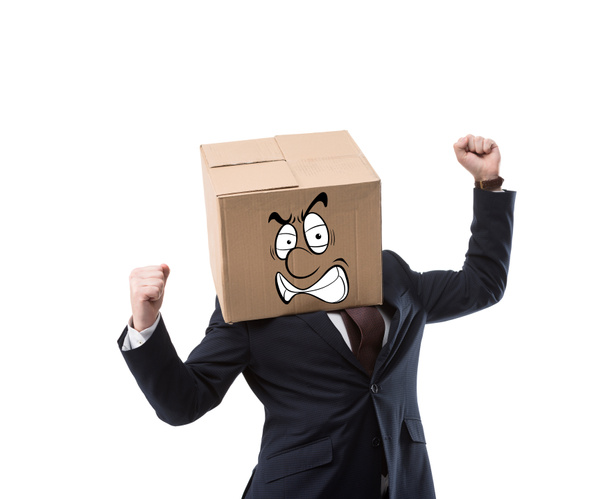 angry businessman with cardboard box on head gesturing with hands isolated on white - Foto, Imagen