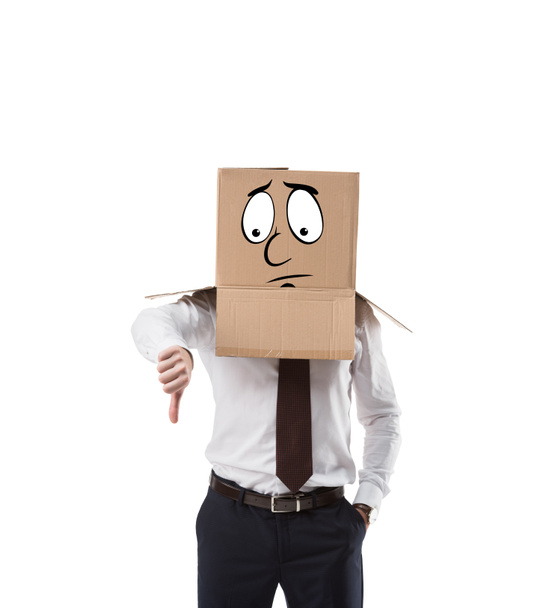 hombre de negocios con caja de cartón en la cabeza mostrando el pulgar hacia abajo aislado en blanco
 - Foto, Imagen