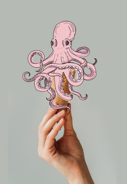 Bijgesneden afbeelding van vrouw met wafel ijsje met octopus geïsoleerd op grijs - Foto, afbeelding