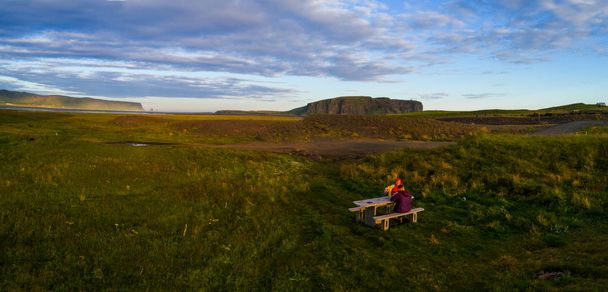 Две туристки сидят за столом в Исландии на закате
 - Фото, изображение