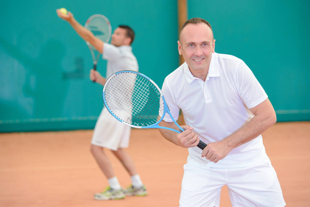 Men playng tennis doubles - Valokuva, kuva