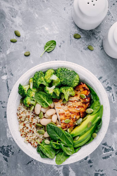 Green buddha bowl lunch with grilled chicken and quinoa, spinach, avocado, broccoli and white beans  - Photo, Image