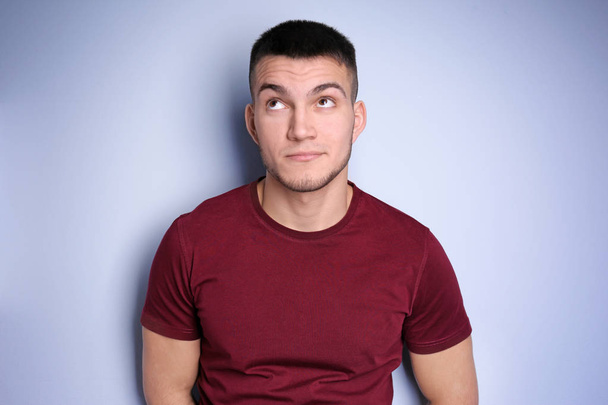 Emotional young man with dyed eyebrows on light background - Foto, imagen