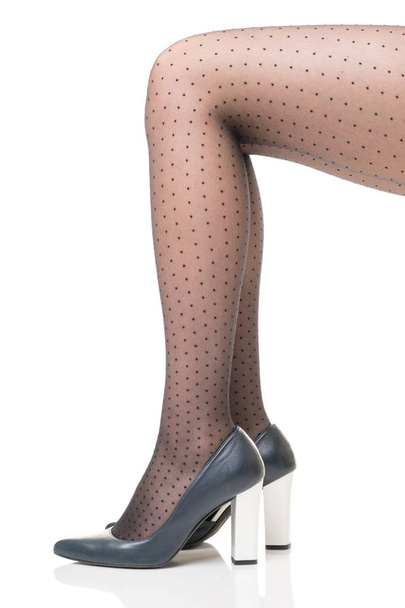 Female legs in black tights with polka dots and in dark blue shoes with high white heels - Φωτογραφία, εικόνα