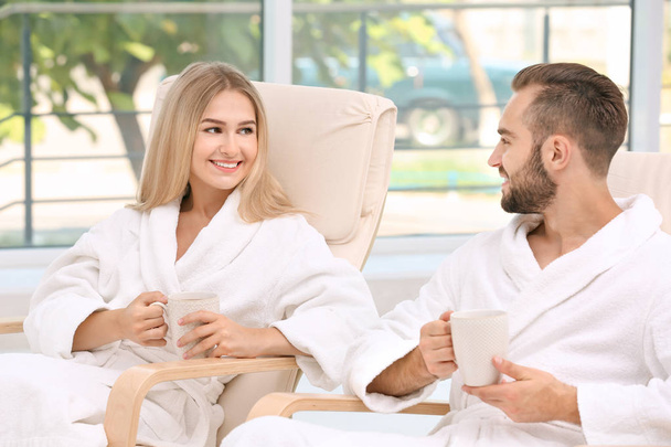 Young couple in bathrobes relaxing indoors - Foto, Imagen