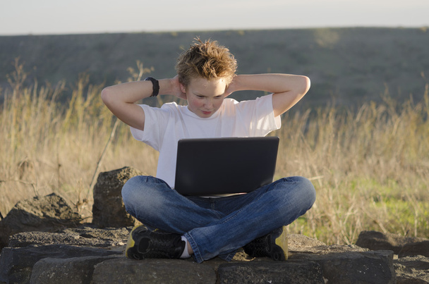 Descanso adolescente com laptop segurar as mãos atrás de sua cabeça
 - Foto, Imagem