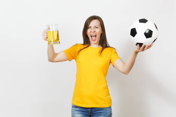 Kaunis eurooppalainen nuori iloinen nainen, jalkapallofani tai pelaaja keltainen yhtenäinen tilalla tuoppi olutta, jalkapallo pallo eristetty valkoisella pohjalla. Urheilu, jalkapallo, terveiden elämäntapojen käsite
. - Valokuva, kuva