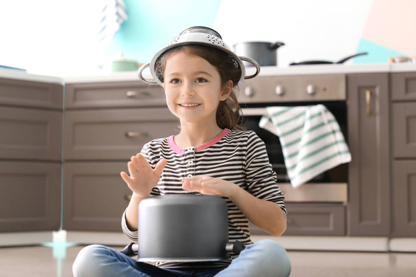 Cute little girl playing with saucepan as drum indoors - Zdjęcie, obraz