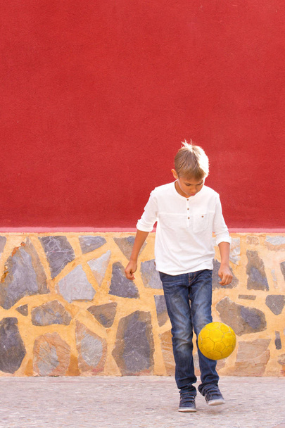 Αγόρι παίζει με μπάλα ποδοσφαίρου σε εξωτερικούς χώρους - Φωτογραφία, εικόνα