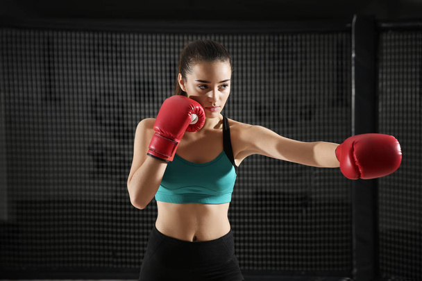 Portrait of young female boxer in gym - Photo, image