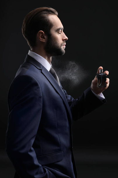Handsome man with bottle of perfume - 写真・画像