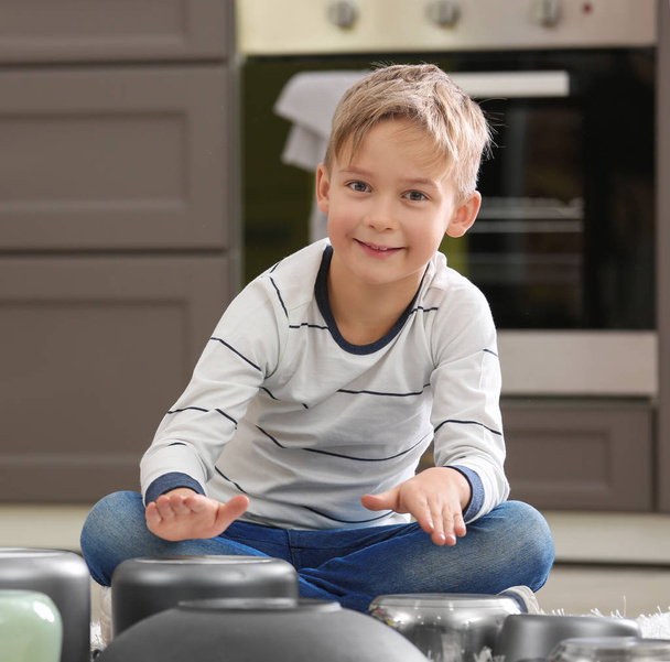 Cute little musician playing drums on kitchenware at home - Foto, immagini