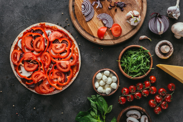 vue de dessus de pizza non cuite avec différents ingrédients sur la table en béton
 - Photo, image