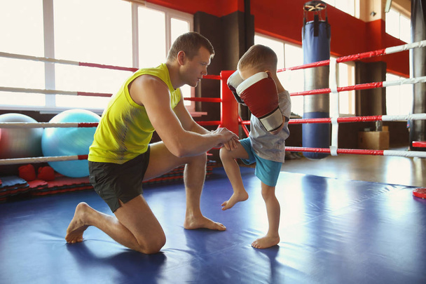 Little boy training with coach in boxing ring - Φωτογραφία, εικόνα