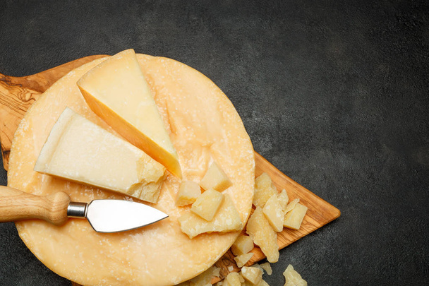 Whole round Head of parmesan or parmigiano hard cheese on concrete background - Фото, зображення