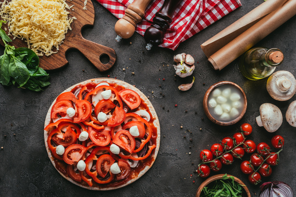 top view of uncooked pizza with ingredients on concrete table - 写真・画像