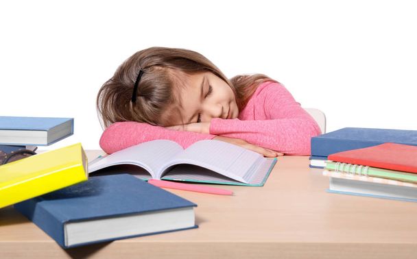 Sleeping little girl tired of doing homework against white background - Foto, Imagem
