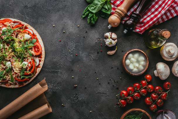 top view of uncooked pizza with ingredients on concrete table - Foto, immagini