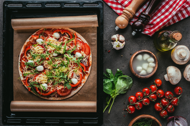 top view of freshly baked pizza with ingredients on concrete table - Фото, зображення