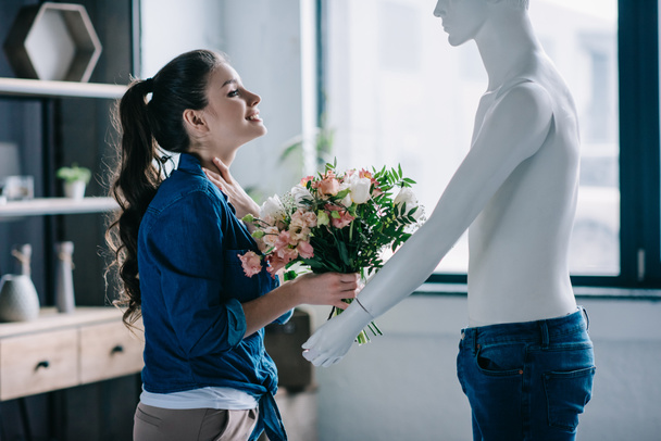 young woman pretending to receive flowers from layman doll, perfect relationship dream concept - Photo, Image