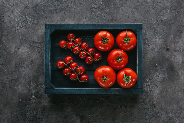 top view of various tomatoes in box on concrete surface - Фото, зображення