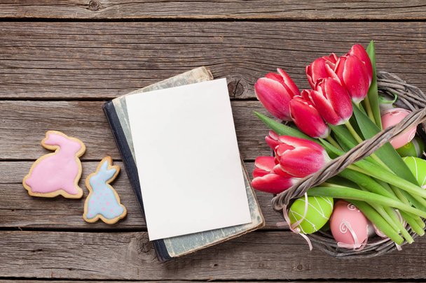 Buquê de tulipas vermelhas, ovos e biscoitos de gengibre de Páscoa. Cartão de saudação pascal com espaço para as vossas saudações. Vista superior
 - Foto, Imagem
