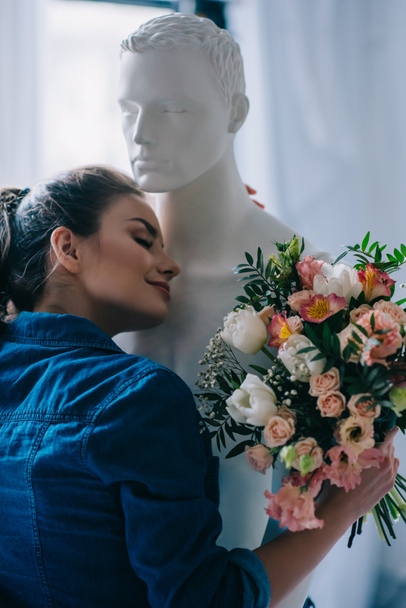 giovane donna con mazzo di fiori abbracciando bambola laica, concetto perfetto rapporto sogno
 - Foto, immagini