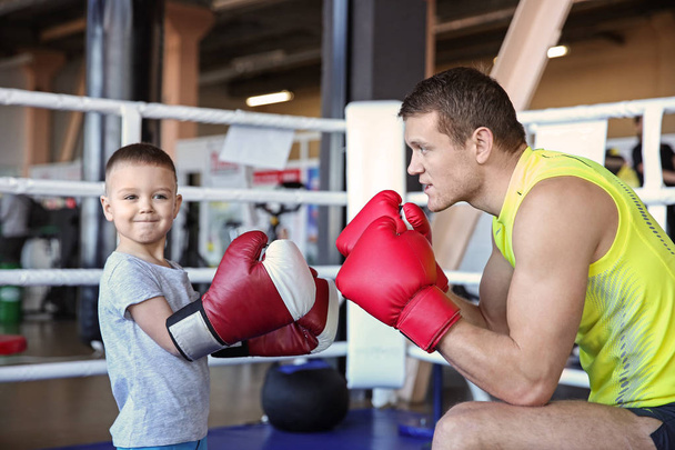 Little boy training with coach in boxing ring - Φωτογραφία, εικόνα