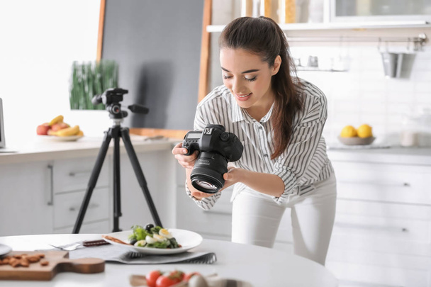 Young woman with professional camera taking still life pictures in kitchen - Foto, imagen