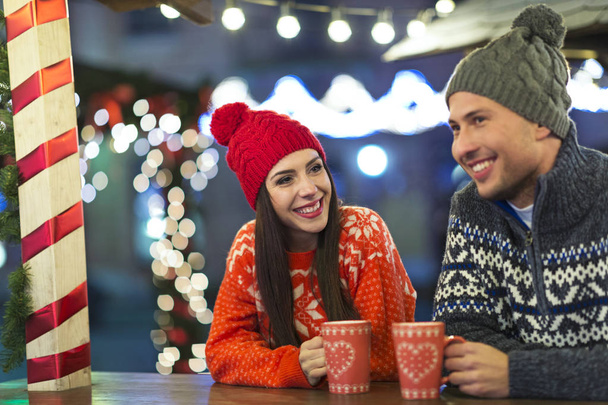 クリスマスの時期に屋外の楽しみを持っている若いカップル - 写真・画像